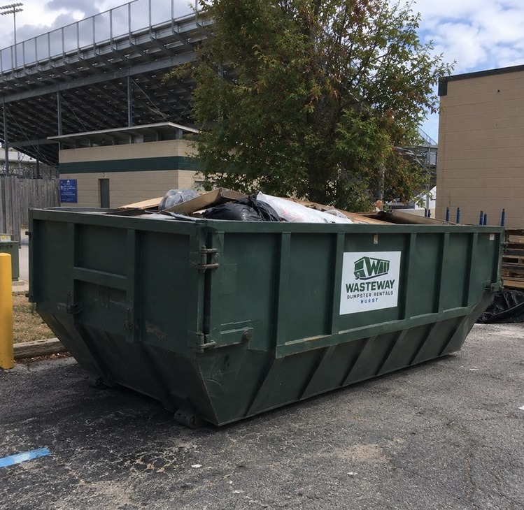 Wasteway roll-off dumpster loaded with construction debris on a jobsite